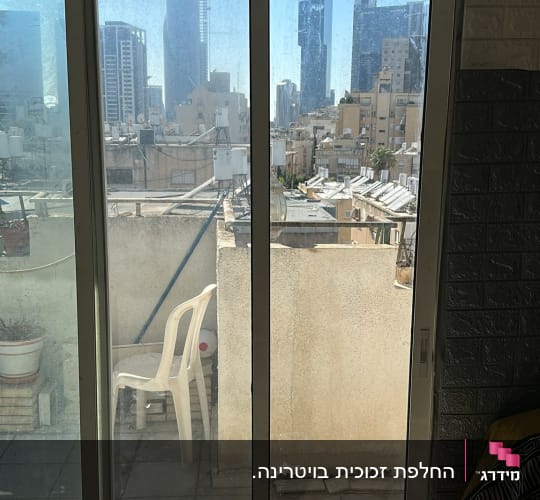 דלתות הזזה מזכוכית ביציאה למרפסת בדירה עירונית